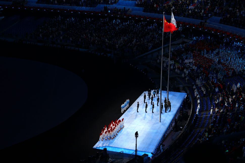 The IOC and Chinese flag are seen flying next to each other during the Opening Ceremony of the Beijing 2022 Winter Olympics at the Beijing National Stadium on February 04, 2022 in Beijing, China.