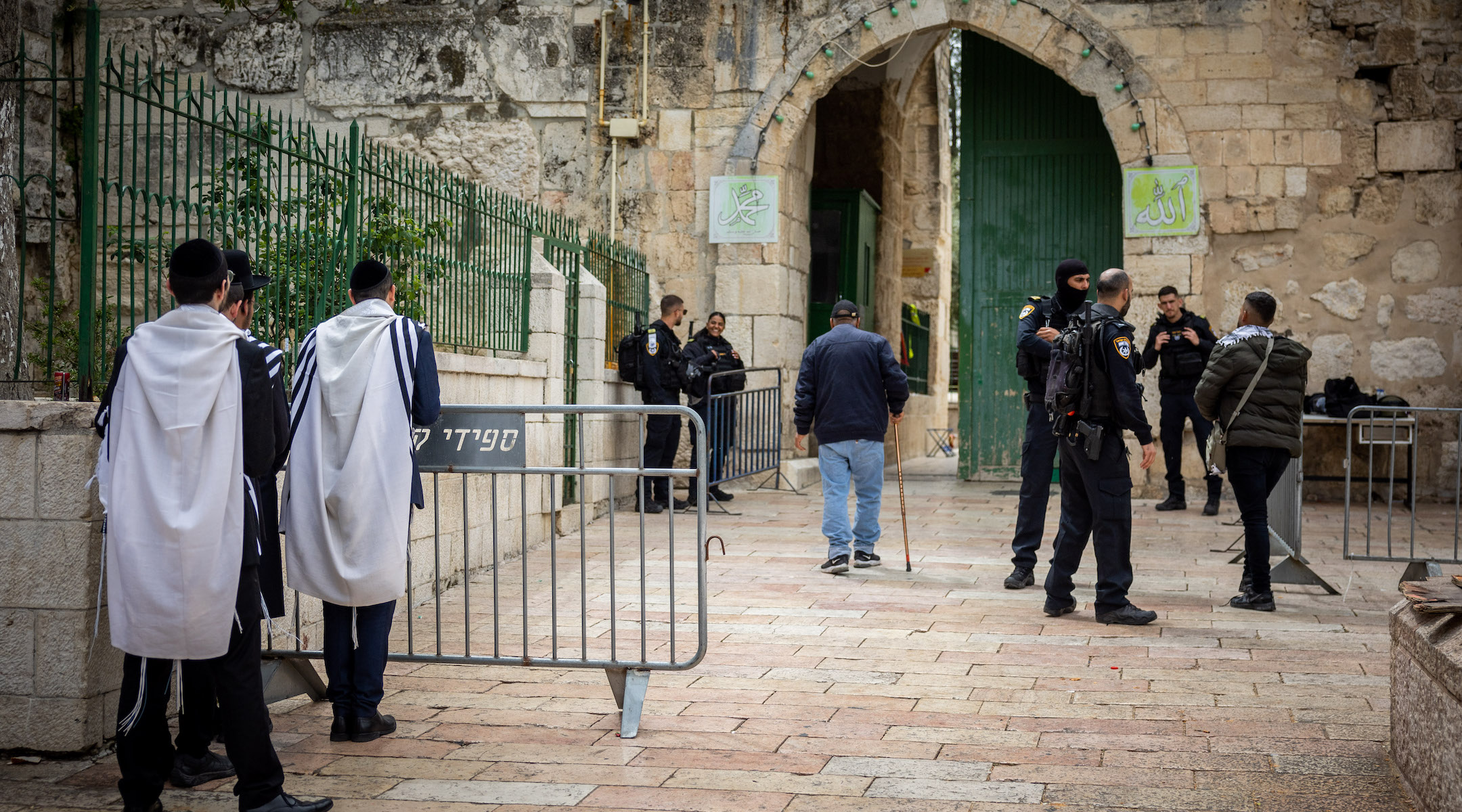 Jewish men pray near the entrance to the Al Aqsa Mosque at the Temple Mount complex in Jerusalem, April 19, 2022. (Yonatan Sindel/Flash90)