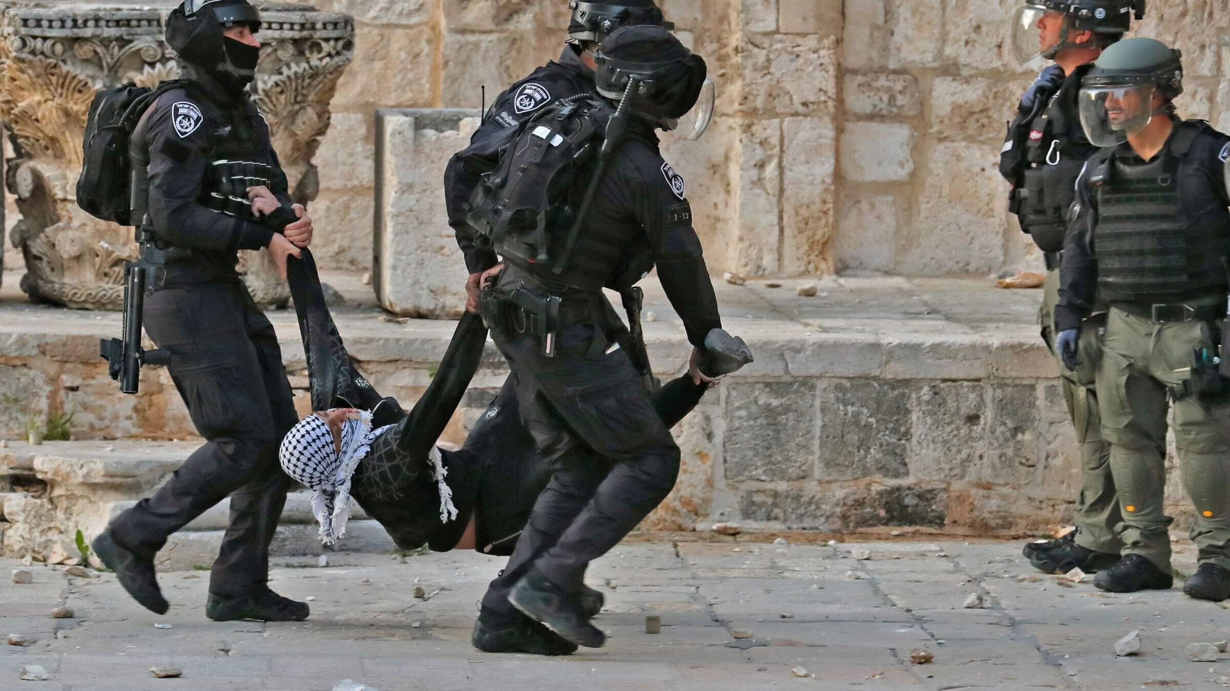 Israeli police carry a wounded young Palestinian demonstrator at Jerusalem's Al-Aqsa mosque compound on April 22, 2022. (Photo by Ahmad GHARABLI / AFP) (Photo by AHMAD GHARABLI/AFP via Getty Images)