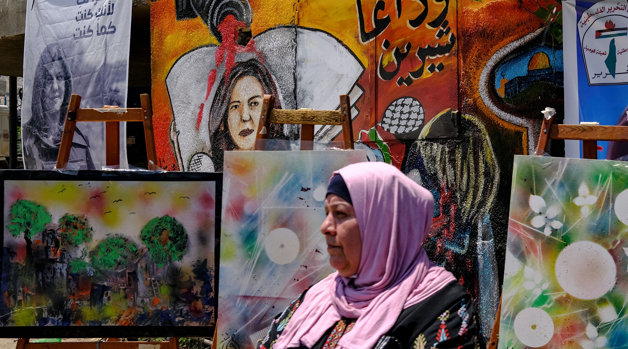 A woman stands in front of a mural, part of an art exhibit honoring slain Palestinian Al-Jazeera journalist Shireen Abu Akleh, at the spot where she was killed in Jenin in the West Bank, May 19, 2022. (Ronaldo Schemidt/AFP via Getty Images)