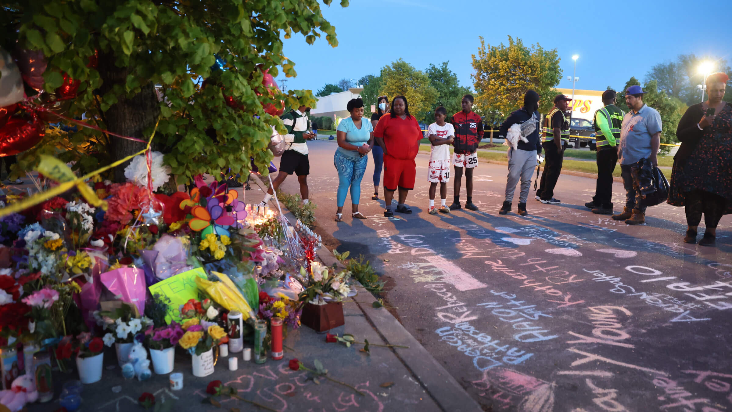 Names of victims and messages of healing are chalked on the ground at a makeshift memorial outside of Tops market on in Buffalo, New York.