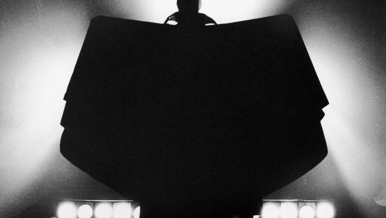 The silhouetted figure of the vampire Count Dracula, raises his cape in batlike-fashion, circa 1970. 