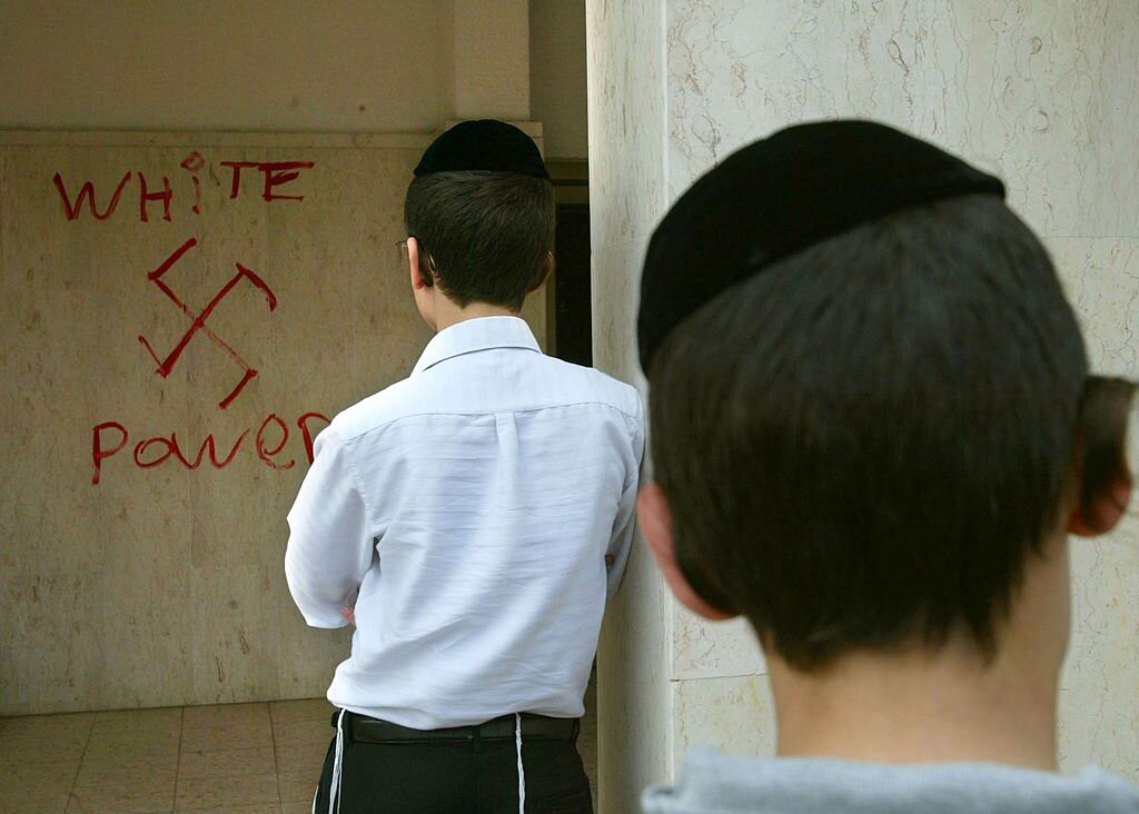 Jewish boys look at anti-semitic graffiti which was sprayed on the walls of a synagogue March 5, 2006 in Petah Tikva, near Tel Aviv, in central Israel. 