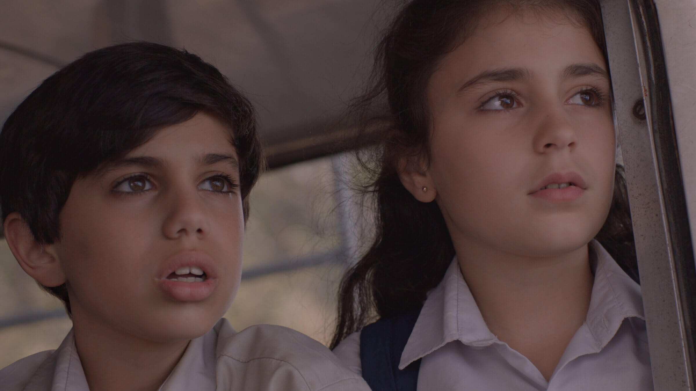 As their school is evacuated, Wissam (Mohamad Dalli) and Joanna (Gia Madi) share a moment of closeness on the bus. 