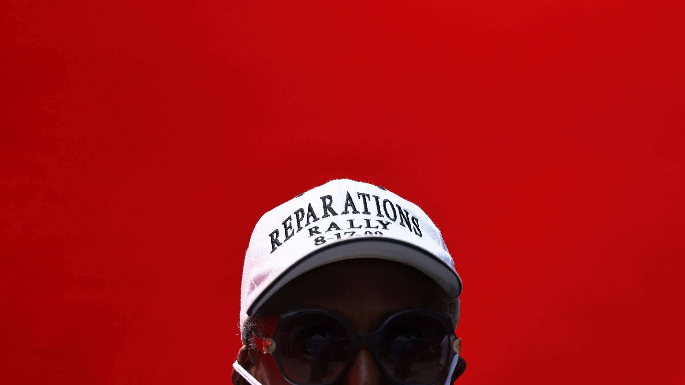 A person wears a Reparations Rally hat during a rally for reparations at the African Burial Ground National Monument on July 23, 2021 in New York City. 