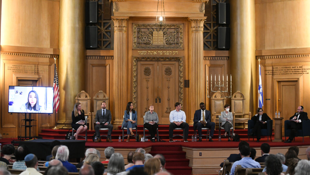 Assemblymember Yuh-Line Niou (left, on video screen), then from left to right, former public defender Maud Maron,  small business owner Brian Robinson, City Councilmember Carlina Rivera,  Assemblymember Jo Anne Simon,  former House impeachment counsel Dan Goldman, Rep. Mondaire Jones and former Rep. Elizabeth Holtzman at the candidate forum for New York's 10th Congressional District co-hosted by the Forward at Congregation Beth Elohim (CBE) in Brooklyn on July 26, 2022.