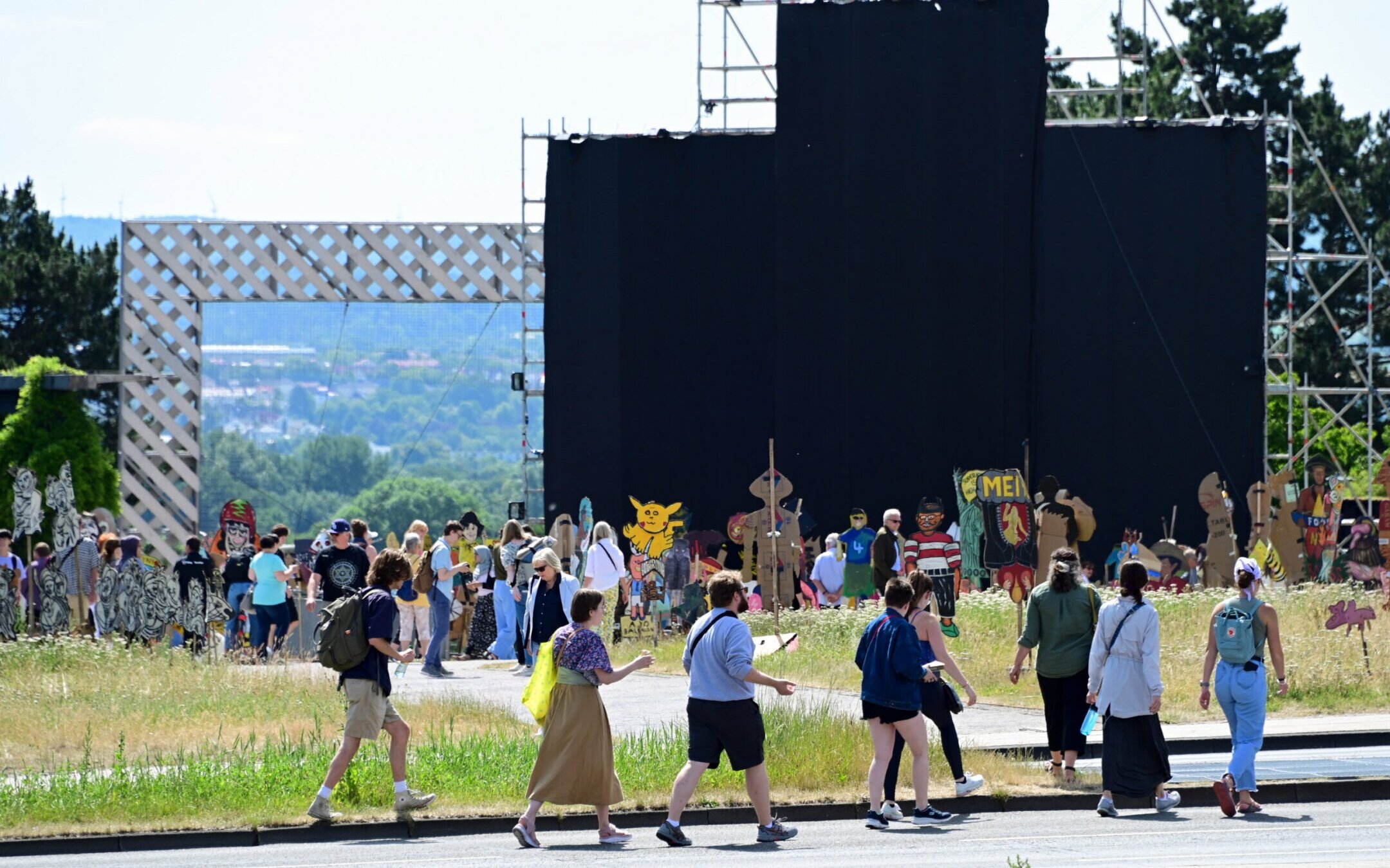 Art lovers look at the large painting “People’s Justice” (2002) by the Indonesian collective Taring Padi, covered with black cloth, on Friedrichsplatz in Kassel, Germany, June 28, 2022. Several antisemitic motifs could be seen on the banner, prompting a debate about the show’s handling of antisemitic content. (Uwe Zucchi/picture alliance via Getty Images)