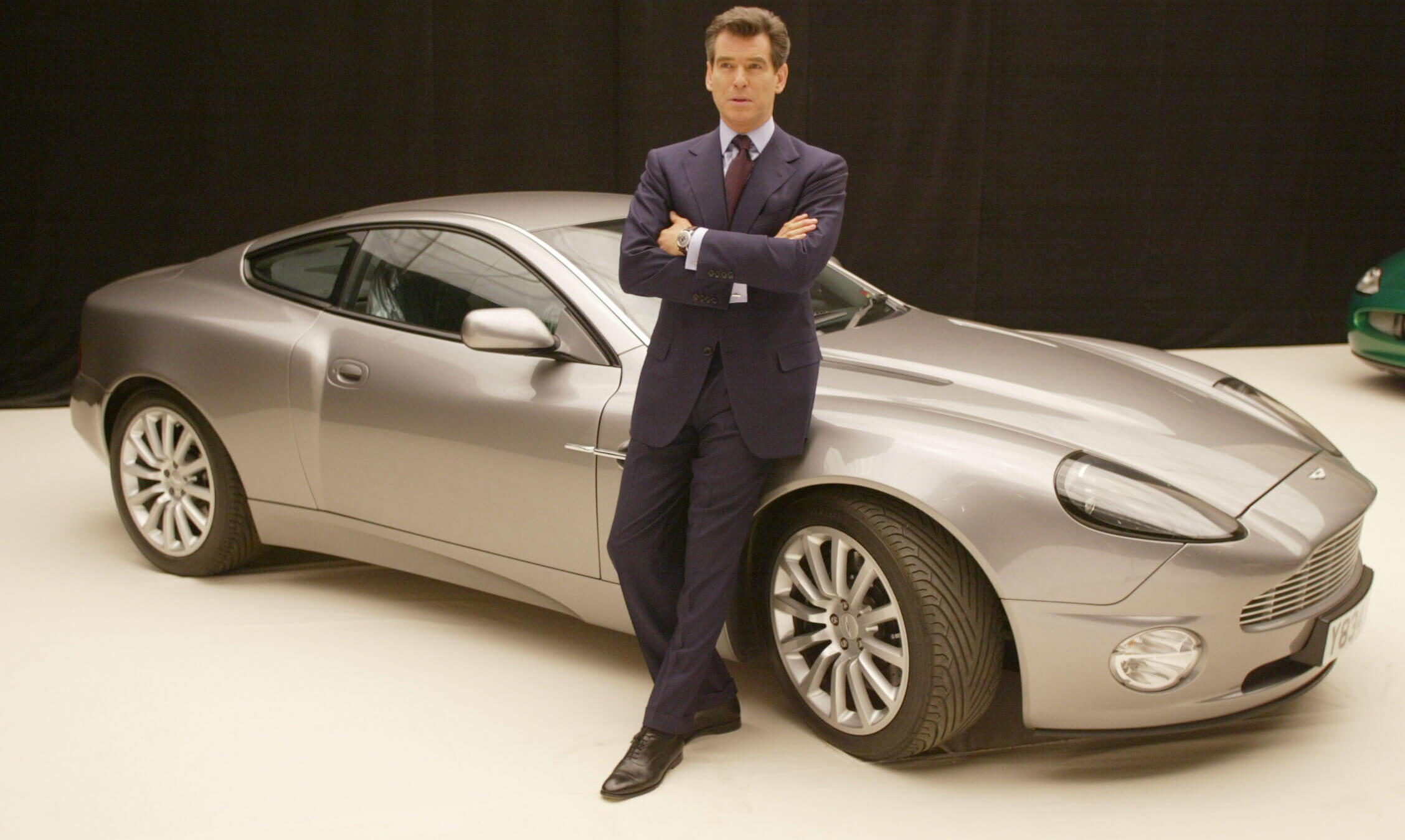 Onetime James Bond actor Pierce Brosnan poses with an Aston Martin to promote the film "Die Another Day."