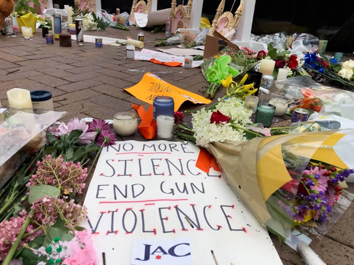 Signs against gun violence are placed at a memorial for the victims of a mass shooting at a Fourth of July parade, on July 6, 2022 in Highland Park, Illinois.