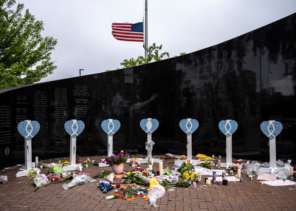 An American flag flies at half-staff near a memorial for the victims of a mass shooting at a Fourth of July parade, on July 6, 2022 in Highland Park, Illinois. 