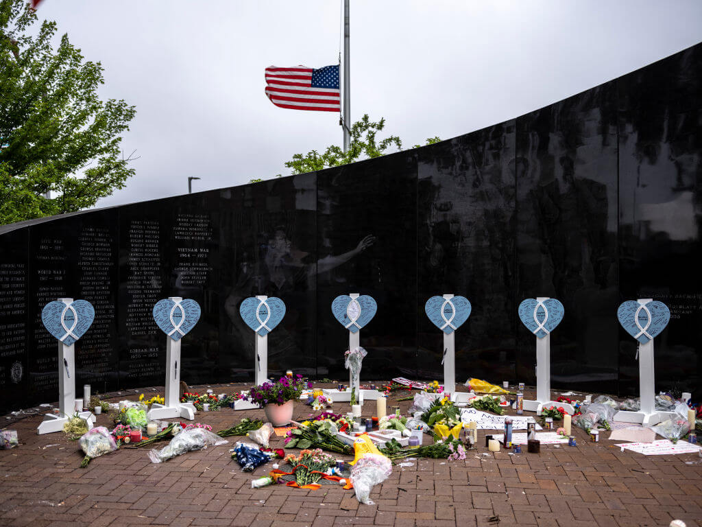 An American flag flies at half-staff near a memorial for the victims of a mass shooting at a Fourth of July parade, on July 6, 2022 in Highland Park, Illinois. 