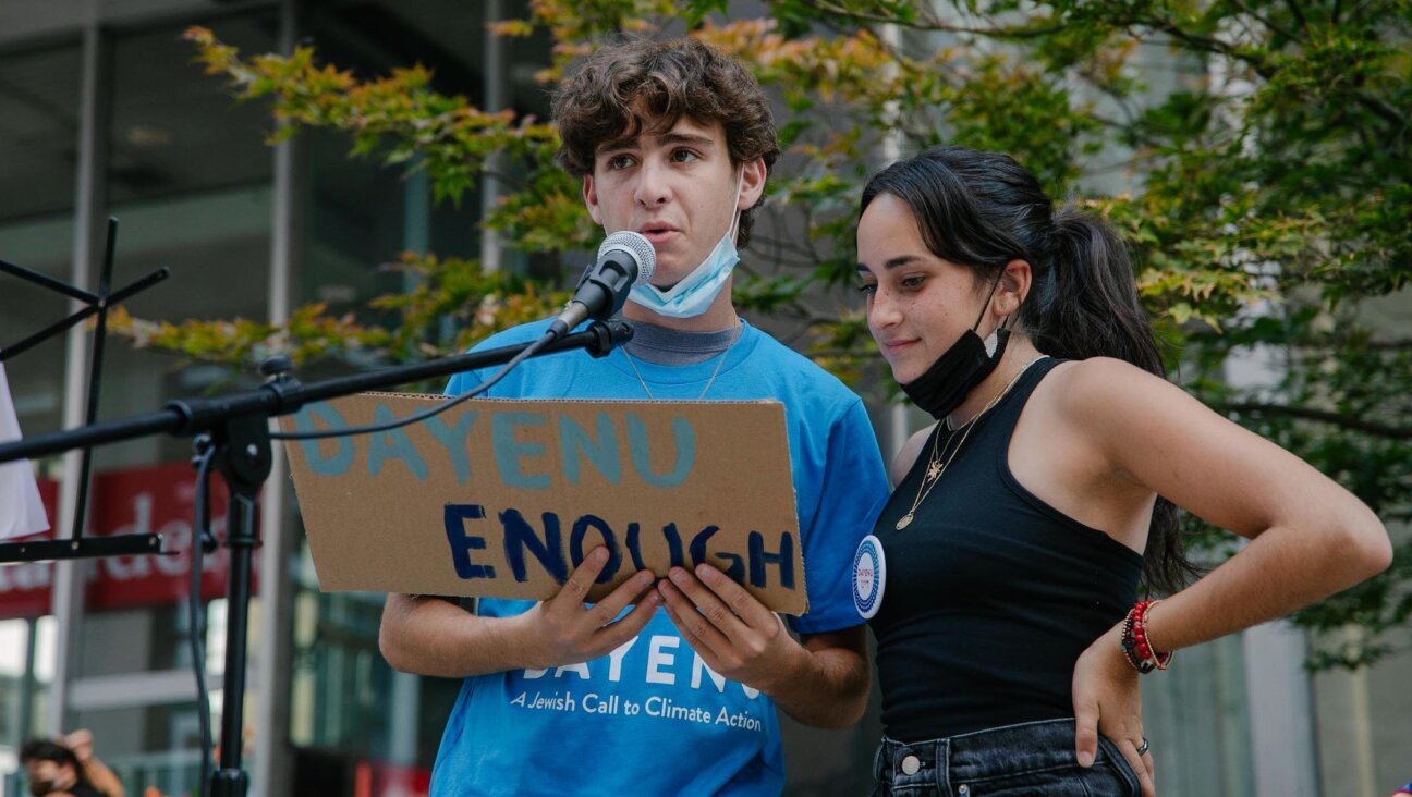 Participants at an event with Dayenu: A Jewish Call to Climate Action hold a sign that says “Dayenu/Enough.” (Rachel Warriner)