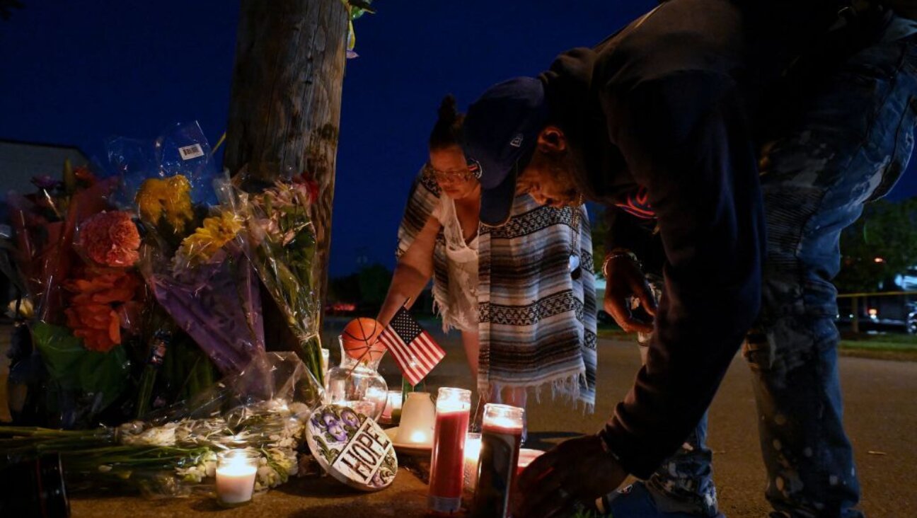 People light candles at a makeshift memorial near a Tops Grocery store in Buffalo, New York, on May 15, 2022, the day after a gunman shot dead 10 people. 