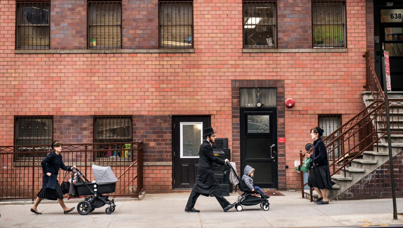 Pedestrians walk past the Yeshiva Kehilath Yakov School in the South Williamsburg neighborhood in the Brooklyn. Hasidic yeshivas, which receive assistance from the UJA-Federation of New York, have been in the spotlight after a state board passed tighter regulations on private schools this week and The New York Times released a scathing investigation critical of some of the yeshivas.