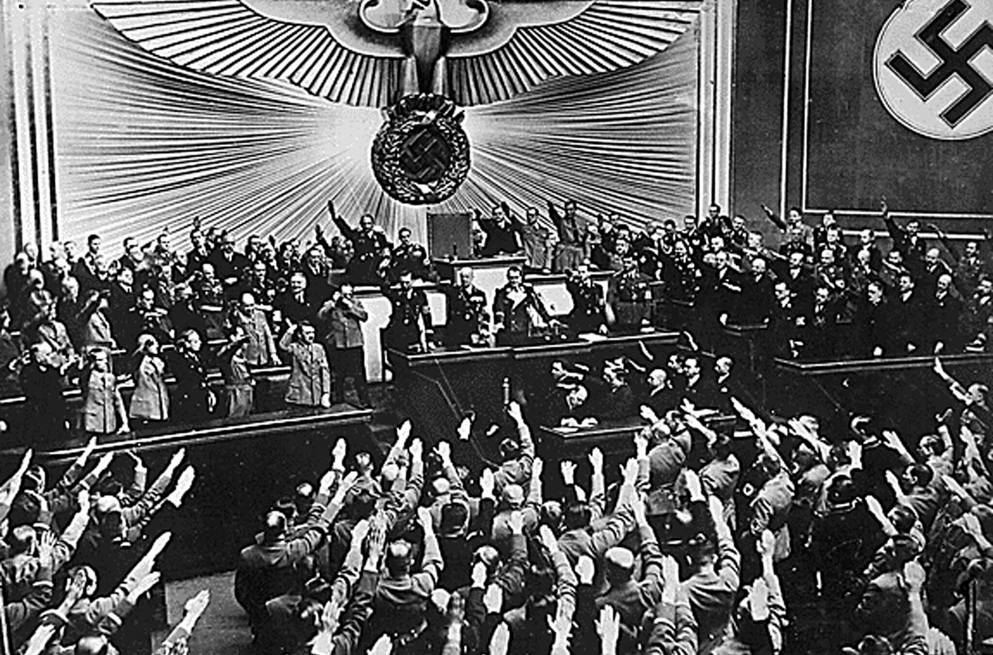 Adolf Hitler receives a one-handed Nazi German salute ovation from the Reichstag.