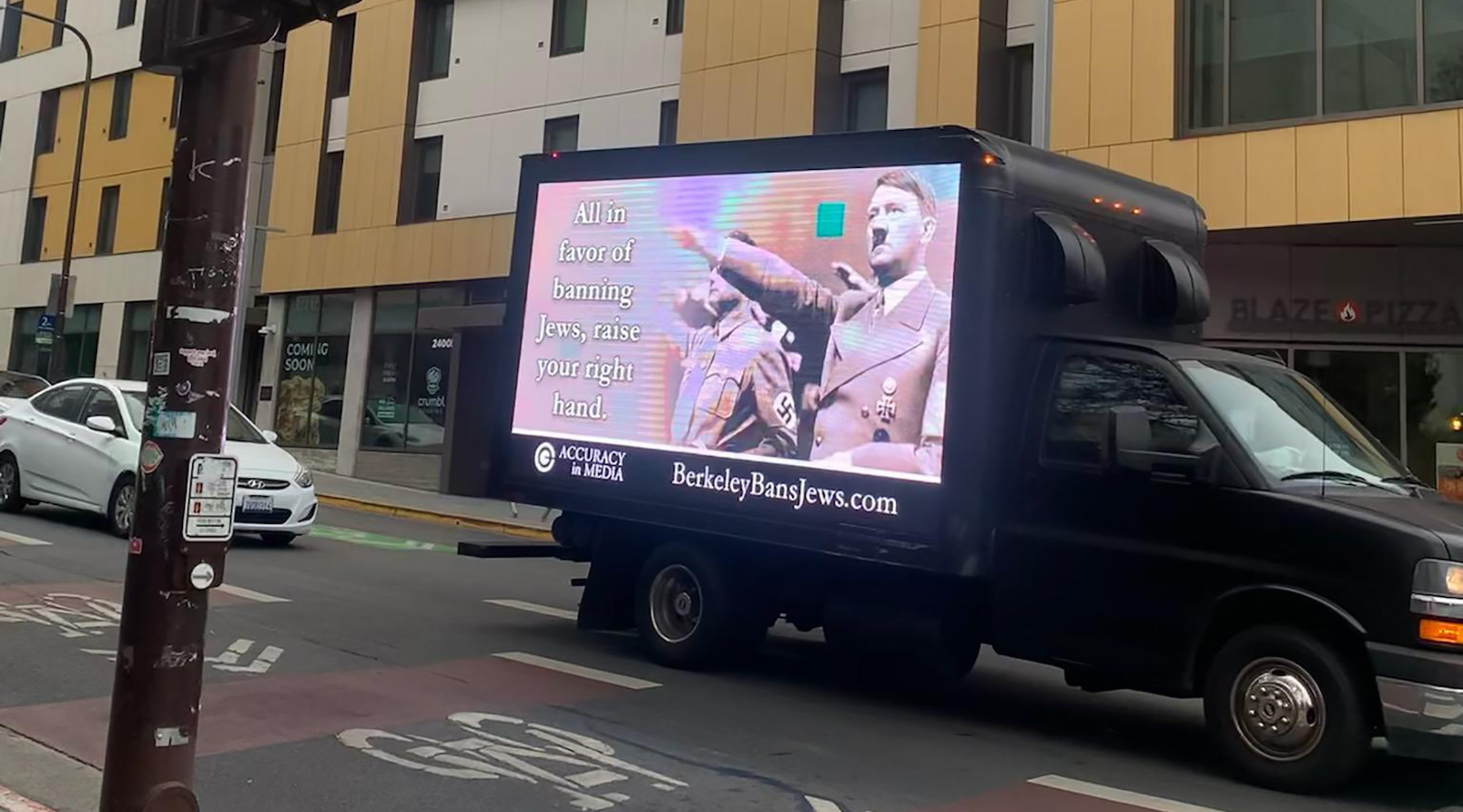 A truck emblazoned with an image of Adolf Hitler and the phrase “All in favor of banning Jews, raise your right hand,” drove through Berkeley, Calif., October 2022, in response to a controversy involving several UC Berkeley Law student groups resolving to bar “Zionist” speakers. (Courtesy of Accuracy in Media)