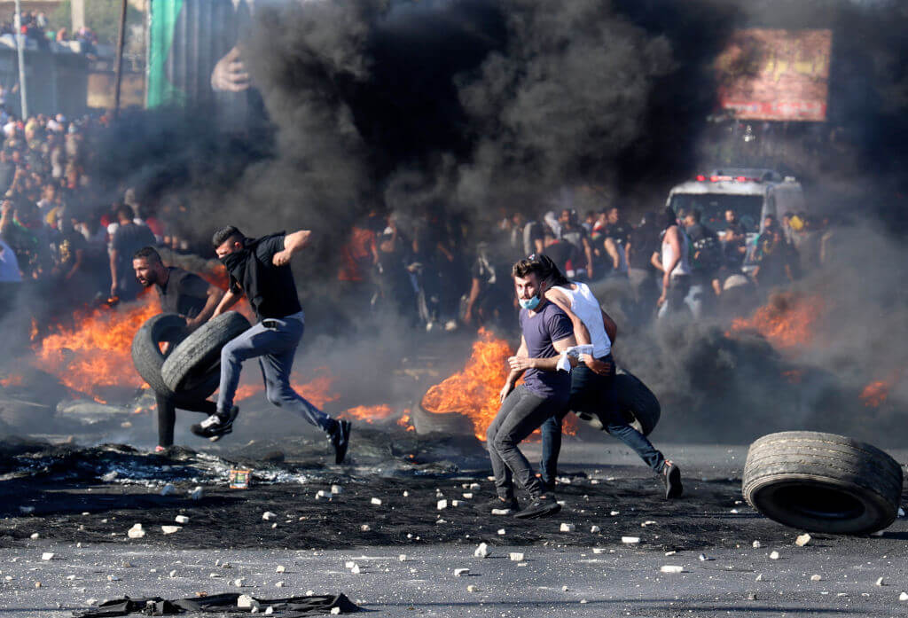 Palestinian protesters confront Israeli troops at the Hawara checkpoint south of Nablus city in the occupied West Bank on May 18, 2021.