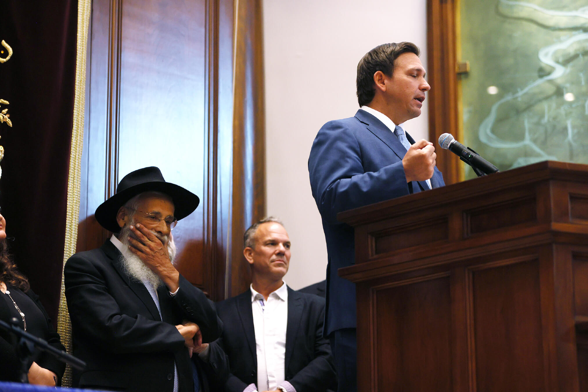 Rabbi Sholom Lipskar listens as Florida Gov. Ron DeSantis speaks during a press conference at the Shul of Bal Harbour on June 14, 2021 in Surfside, Florida. 