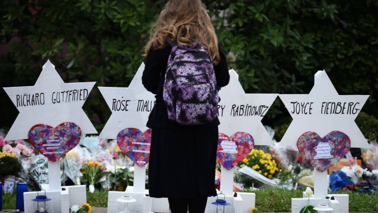 A child stands at a memorial outside the Tree of Life synagogue after a shooting there left 11 people dead in the Squirrel Hill neighborhood of Pittsburgh. 