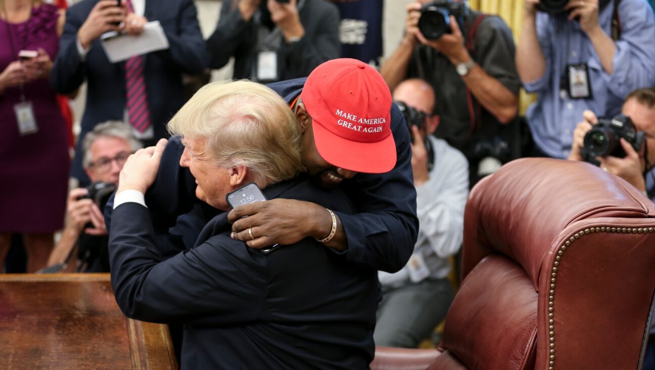 Rapper Kanye West hugs U.S. President Donald Trump during a meeting in the Oval office of the White House, Oct. 11, 2018. (Oliver Contreras – Pool/Getty Images)