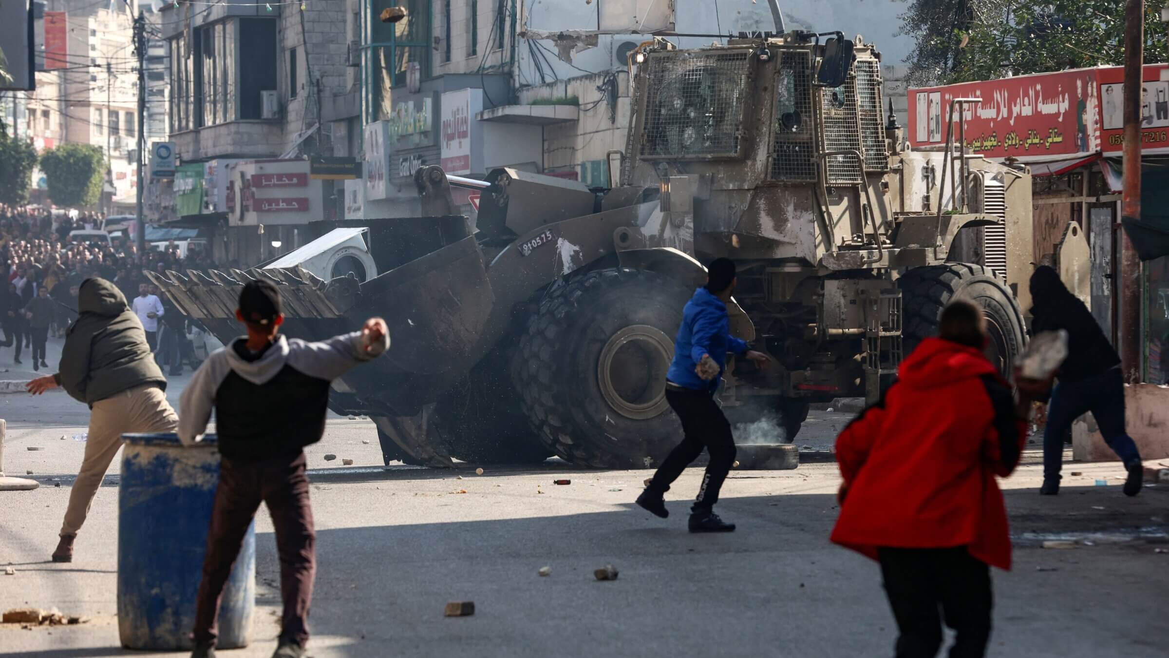 Palestinians hurl rocks at an Israeli army bulldozer, during confrontations in the occupied-West Bank city of Jenin.
