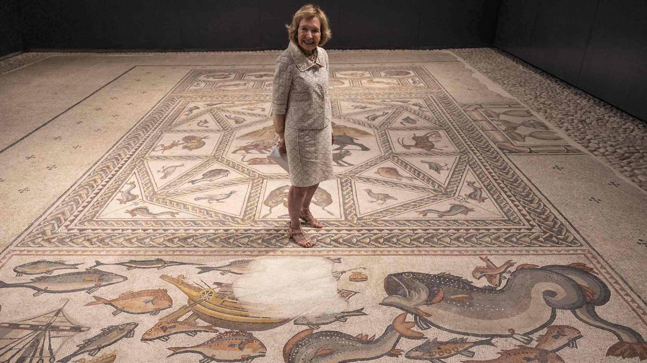 Philanthropist Shelby White poses for a picture on the roughly 1,700-year-old Lod mosaic, ahead of the inauguration of a new visitors center she helped fund to display the prized piece in the Israeli city of Lod, June 27, 2022. (Menahem Kahana/AFP via Getty Images)