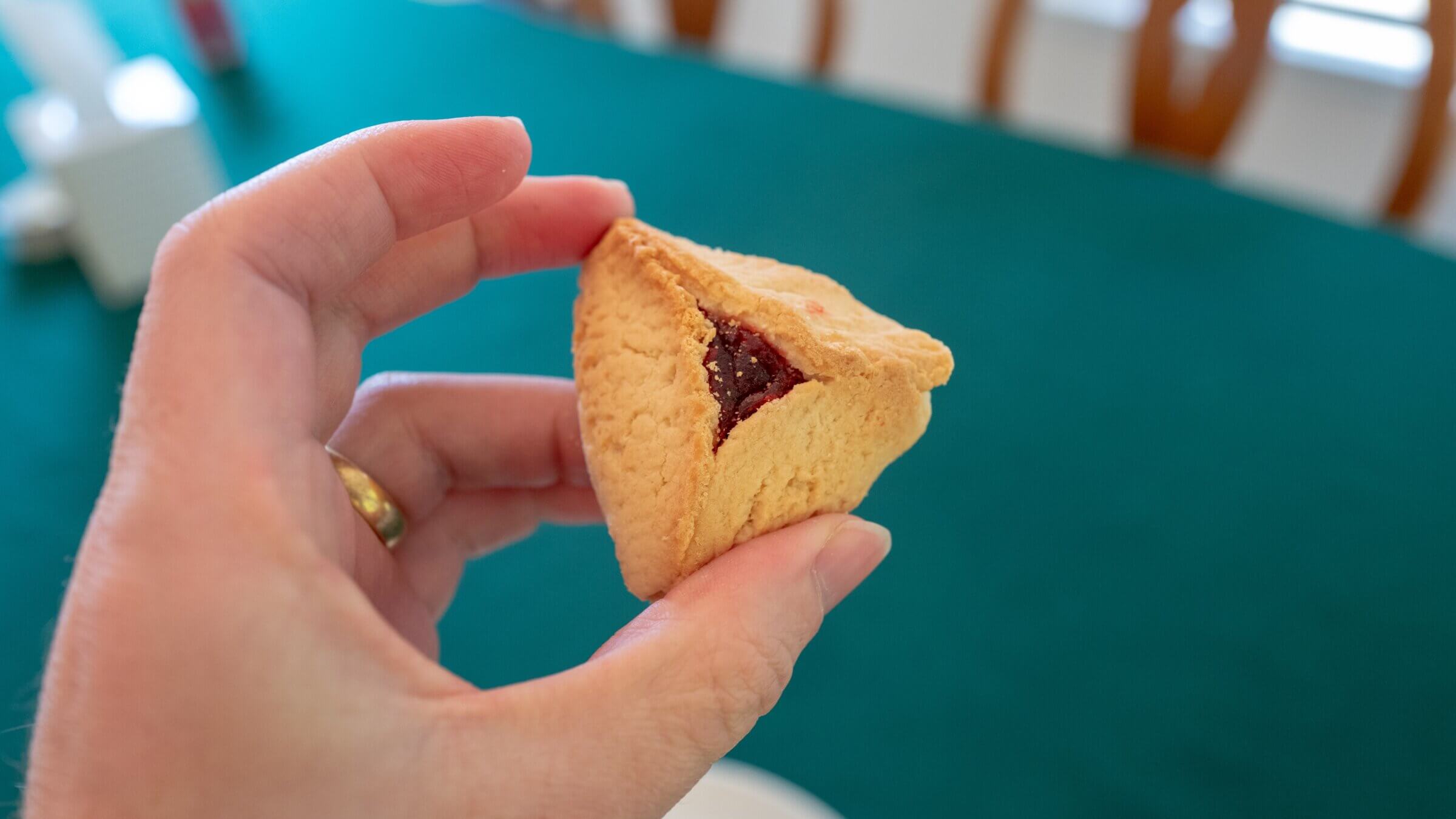 Close-up of hand holding hamantaschen cookie, a traditional food item served during the Jewish holiday of Purim, Lafayette, California, February 26, 2021. 