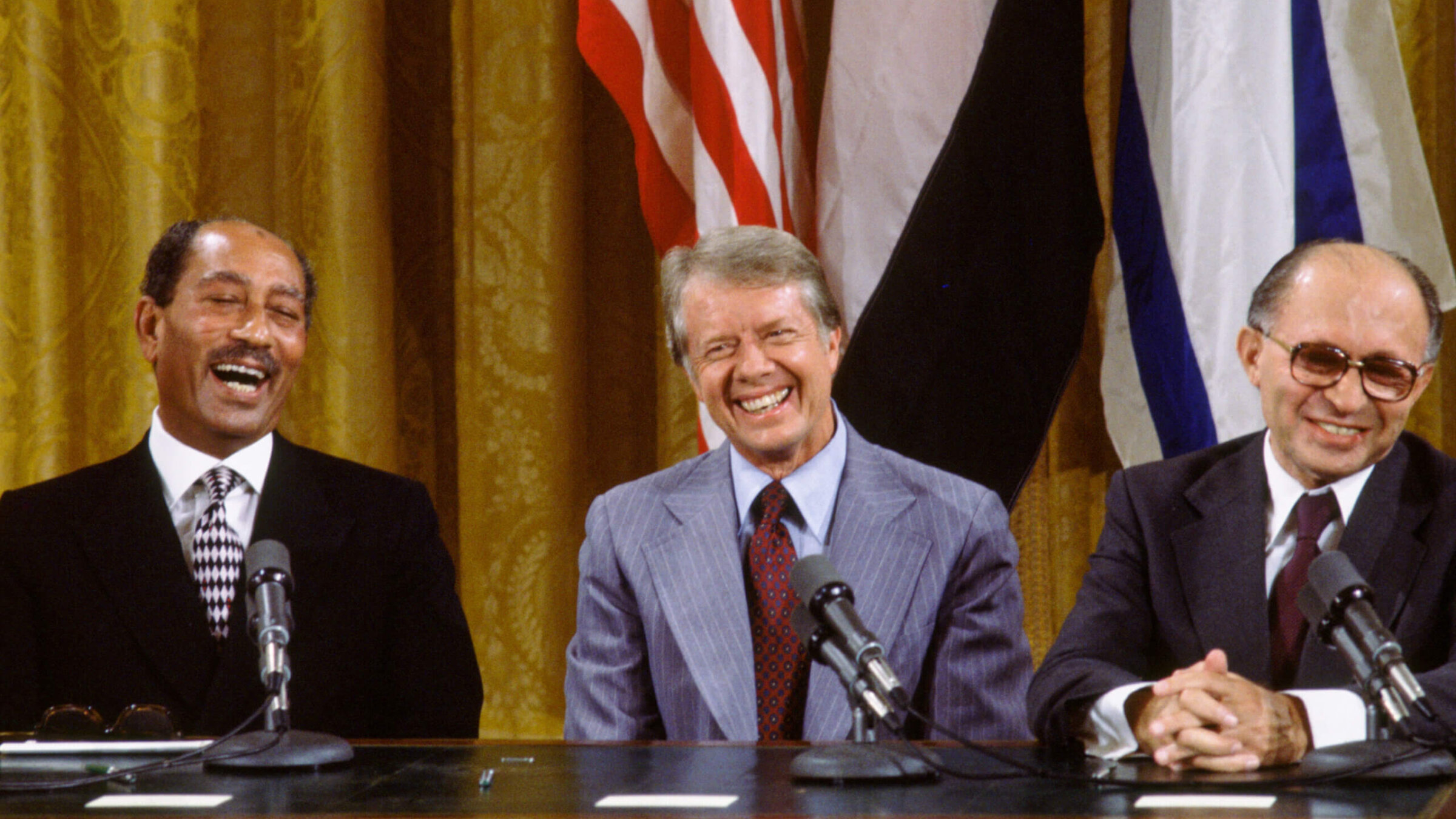 (L to R) Egyptian President Anwar Sadat, US President Jimmy Carter, and Israeli Premier Menachem Begin laugh together during the signing the Camp David Accords in the East Room of the White House, Sept. 18, 1978, in Washington, DC. The agreement came after twelve days of secret negotiations at Camp David.