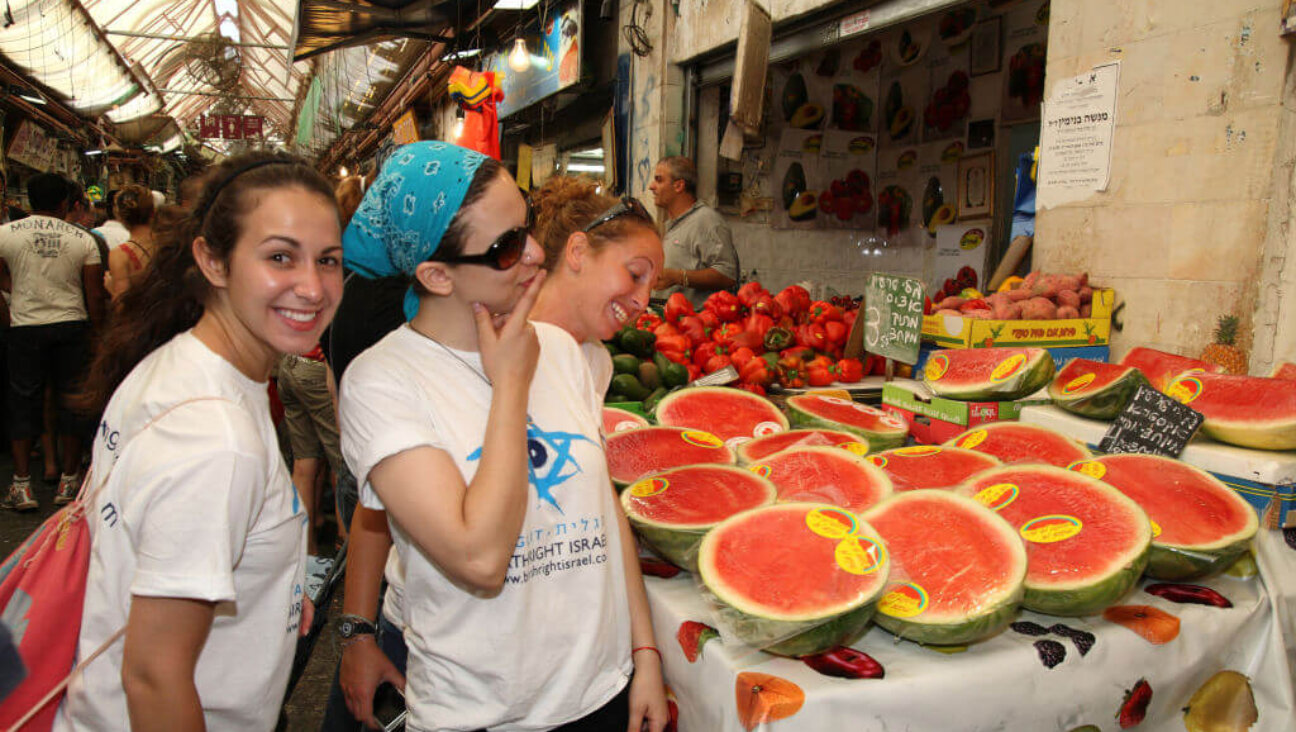 Three young American tourists on the Birthright (Taglit) program checking out the watermelon on a fruit stand in the Machane Yehuda Market, Jerusalem, Israel, August 28, 2009. 