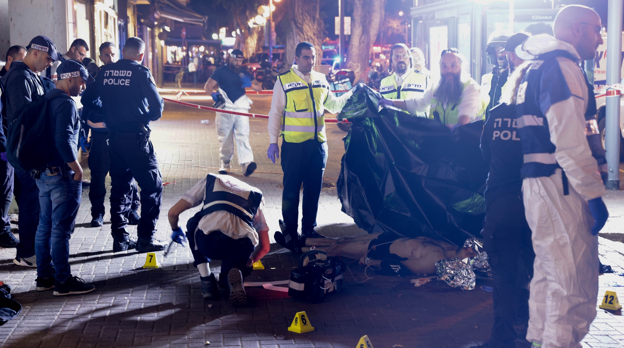 Rescue forces standing next to the body of the terrorist at the scene of a terror attack on Dizengoff street, in central Tel Aviv, March 9, 2023. (Erik Marmor/Flash90)