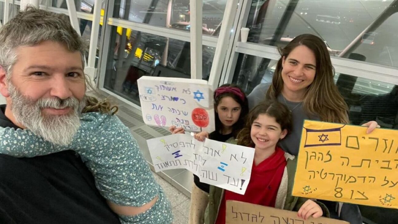 The Breakstone Roth family poses with protest signs in New York City’s John F. Kennedy International Airport en route to Israel, March 27, 2023. 