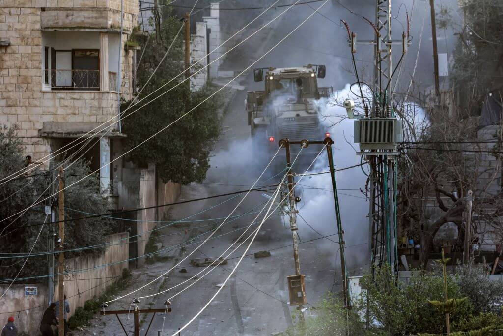 Israeli army vehicles move along a road during a raid in the Jenin camp for Palestinian refugees in the occupied West Bank on March 7, 2023. 