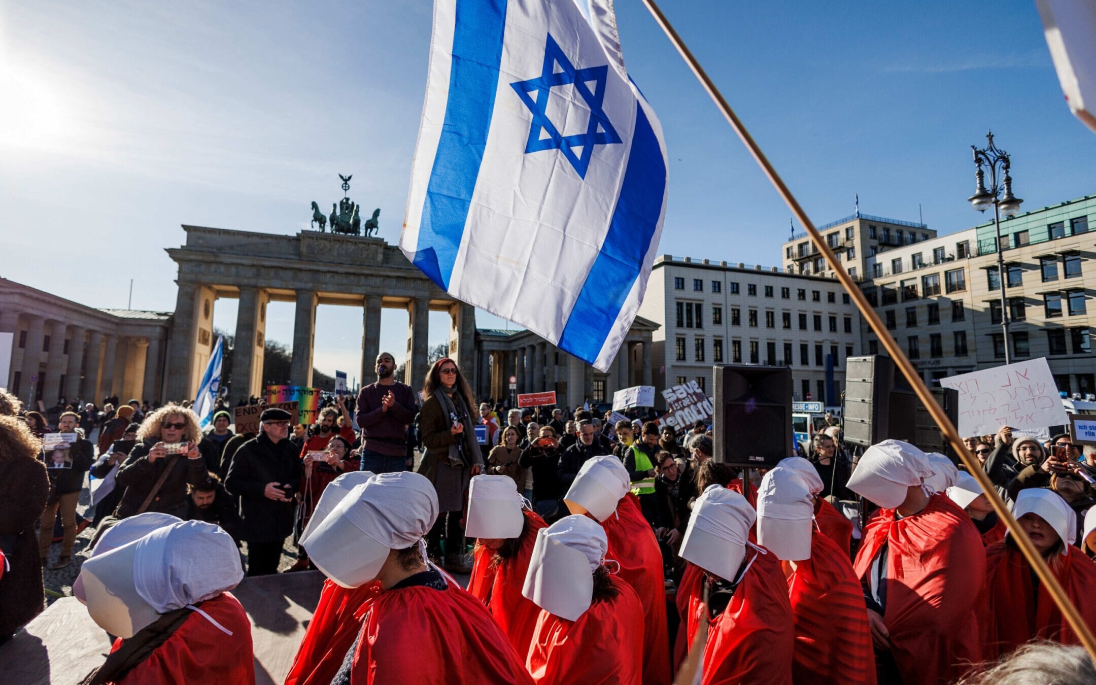 Demonstrators dressed in red costumes inspired by “The Handmaid’s Tale” protest against the Israeli government in front of the Brandenburg Gate on the occasion of the Israeli prime minister’s visit to Berlin. (Carsten Koall/picture alliance via Getty Images)