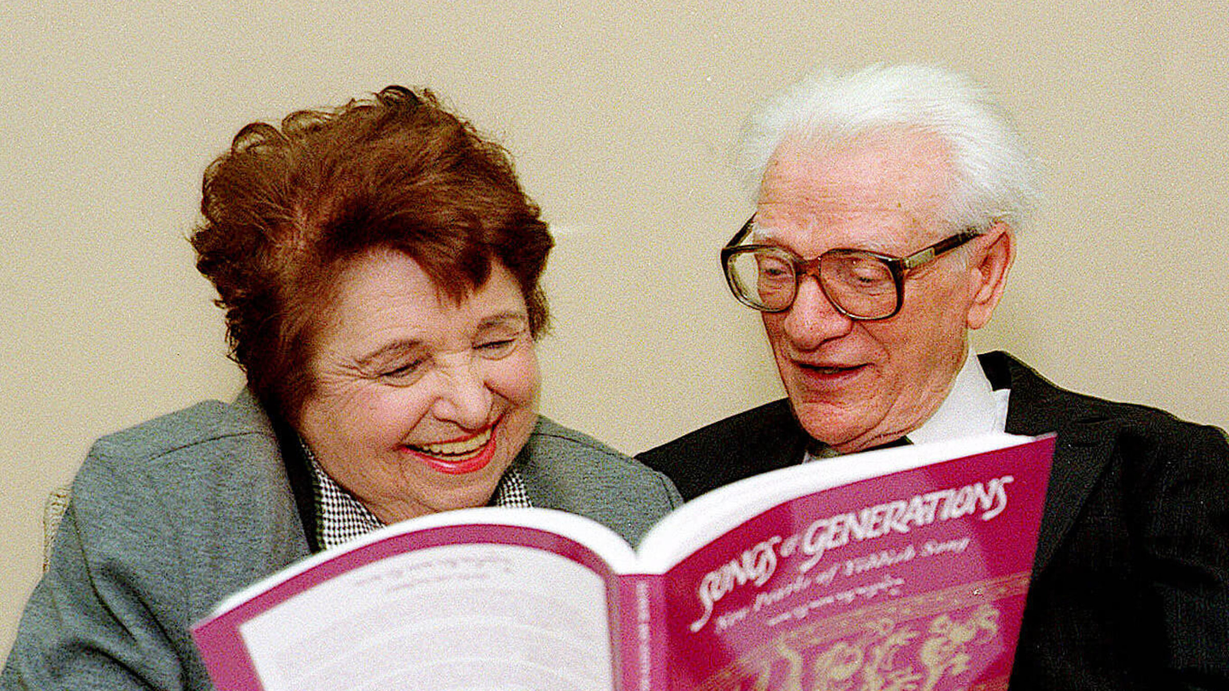 Chana and Yosl Mlotek with one of their signature Yiddish songbooks, "Songs of Generations"