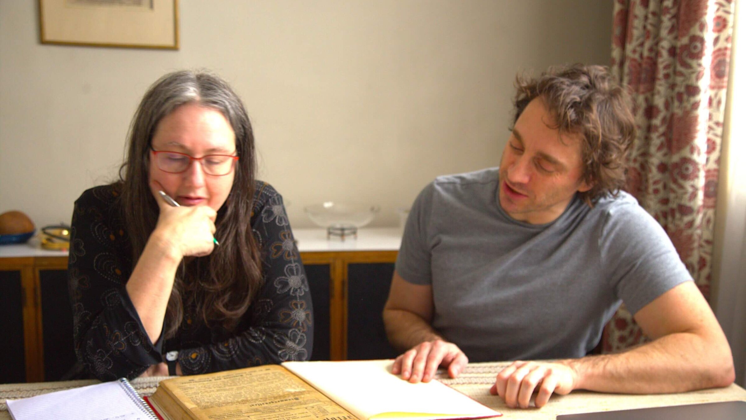 Naomi Seidman and Kalman Weiser looking through some rare town records at the home of David Birnbaum, in Toronto