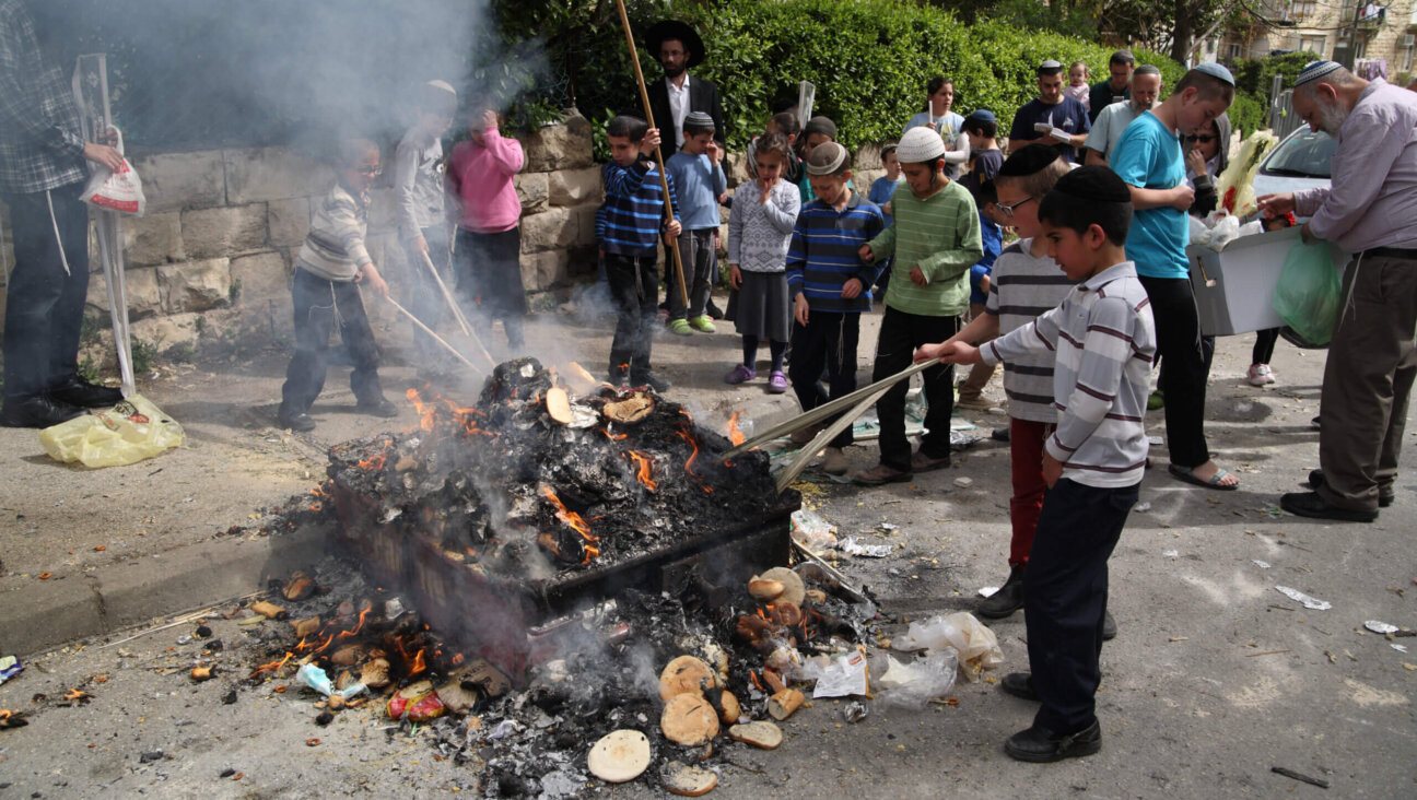 In the Kiryat Moshe neighborhood in Jerusalem, children poke at embers in the Orthodox Jewish practice of burning chametz (leaven, or not Kosher foods) on the morning of Passover eve, Jerusalem, Israel, April 10, 2017. 