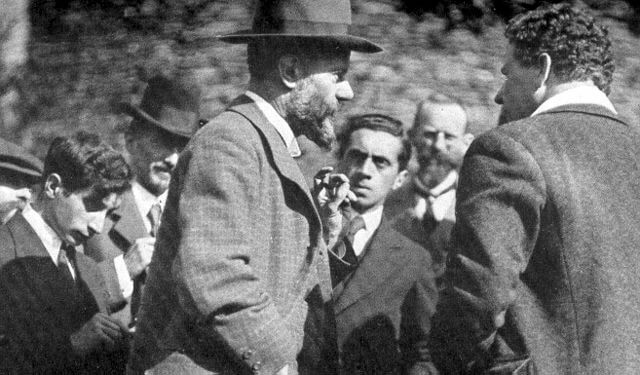 Ernst Toller (background) in a crowd listening to economist Max Weber.