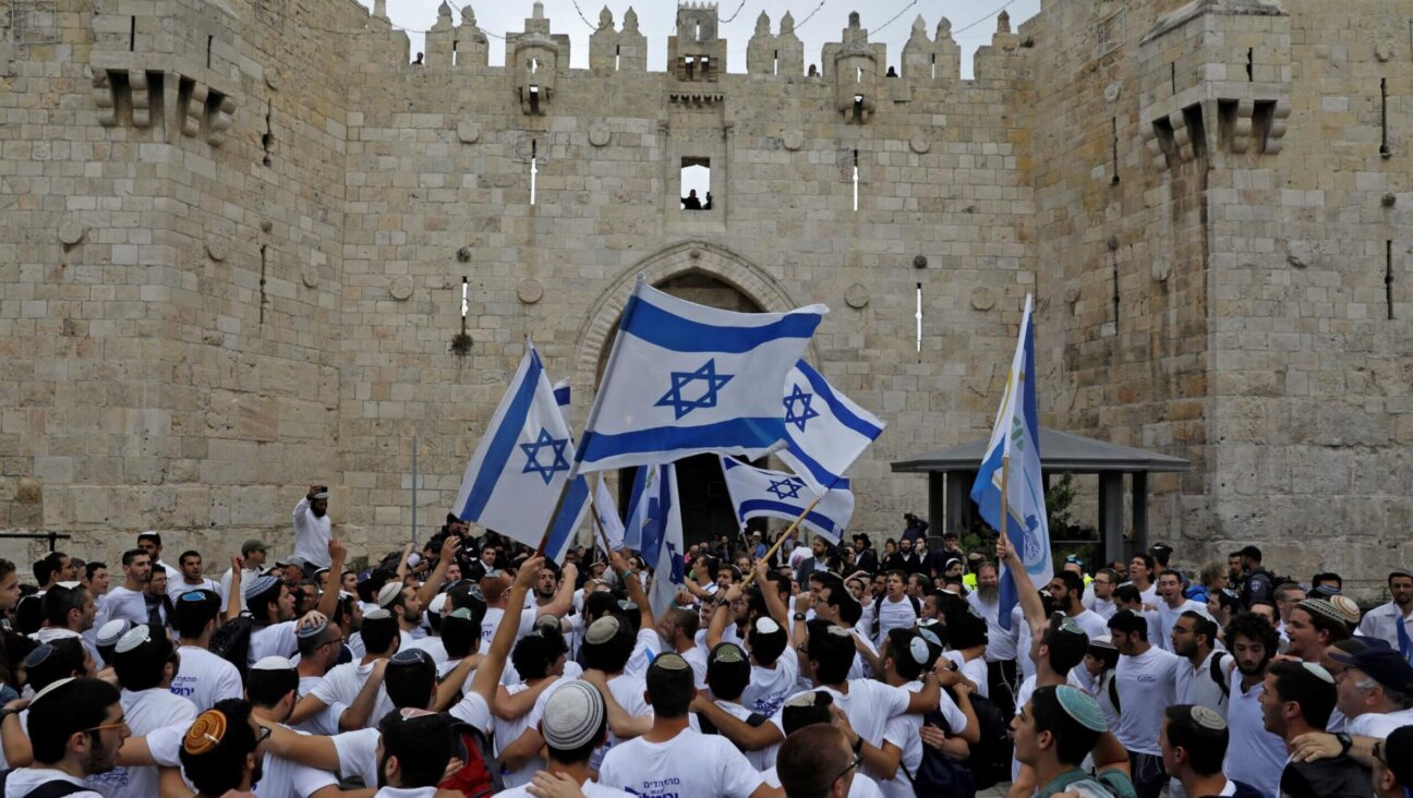 Israeli nationalist settlers wave their national flag as they celebrate the Jerusalem Day at the Old City's Damascus gate in Jerusalem on May 13, 2018. 