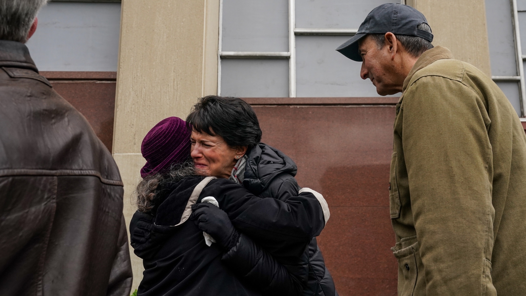 Andrea Wedner, center, one of two worshippers who were shot but survived in the 2018 Tree of Life Synagogue shooting, gets an emotional embrace at the conclusion of a ceremony to say l’hitraot, or until we see each other again, to the Tree of Life building ahead of planned construction in Pittsburgh on April 23, 2023.