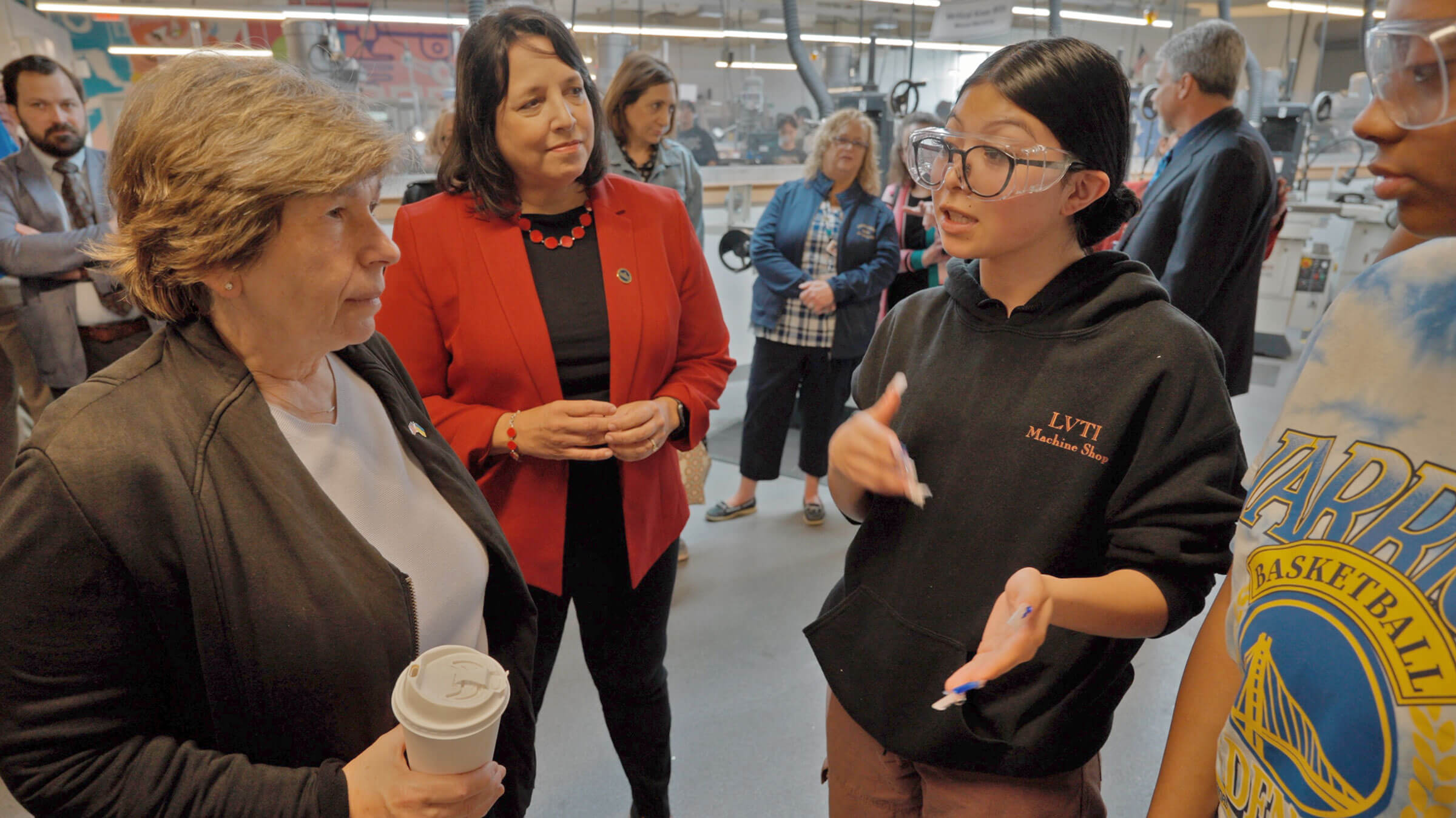 Weingarten, left, and Mass. Lt. Gov. Kim Driscoll, center, listen to a student at Lynn Vocational and Technical High School in Lynn, Mass., on June 9.