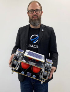 Kfir Damari holding a model of the Beresheet 2 spacecraft.