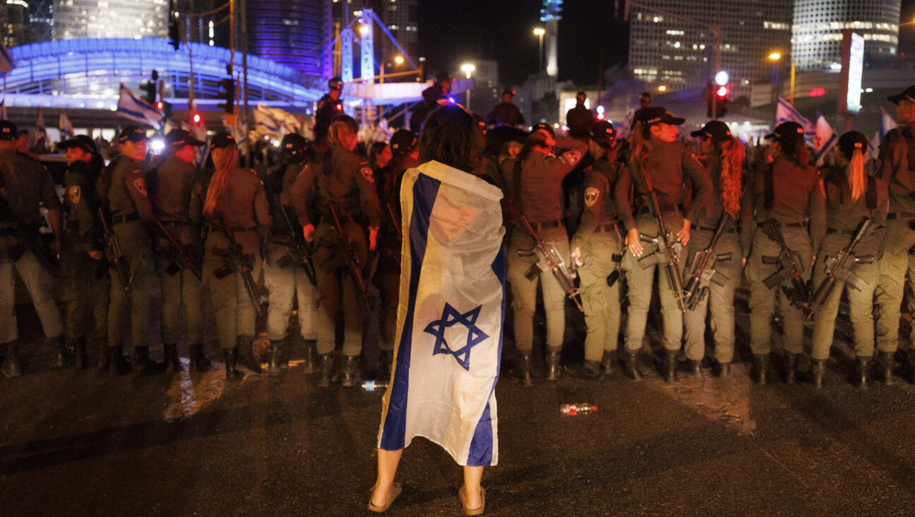 A protestor draped in an Israeli flag during a demonstration against the judicial reform bill outside the Knesset, Israel's parliament, in Jerusalem, Israel, on Monday, July 24, 2023. 