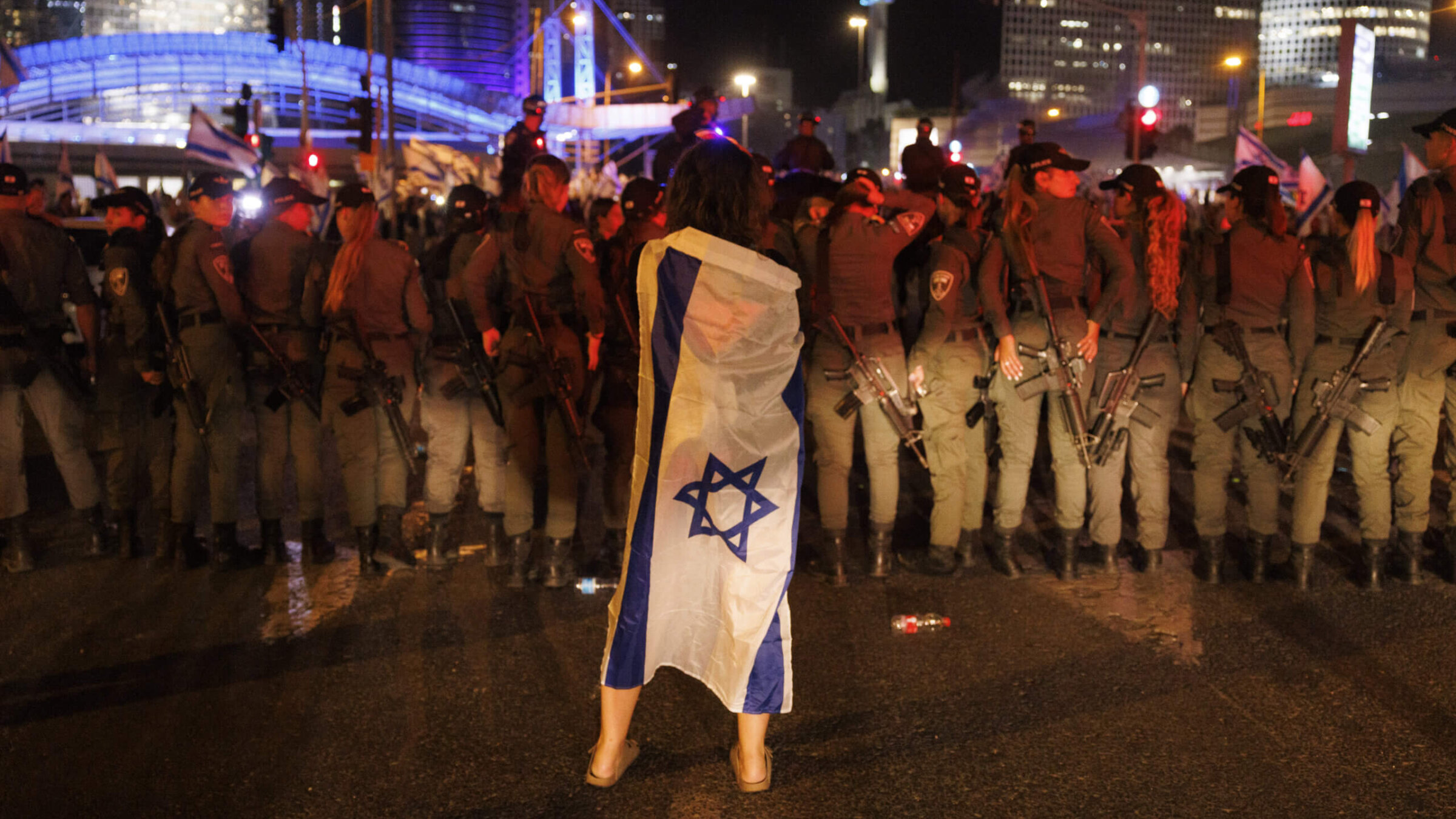 A protestor draped in an Israeli flag during a demonstration against the judicial reform bill outside the Knesset, Israel's parliament, in Jerusalem, Israel, on Monday, July 24, 2023. 