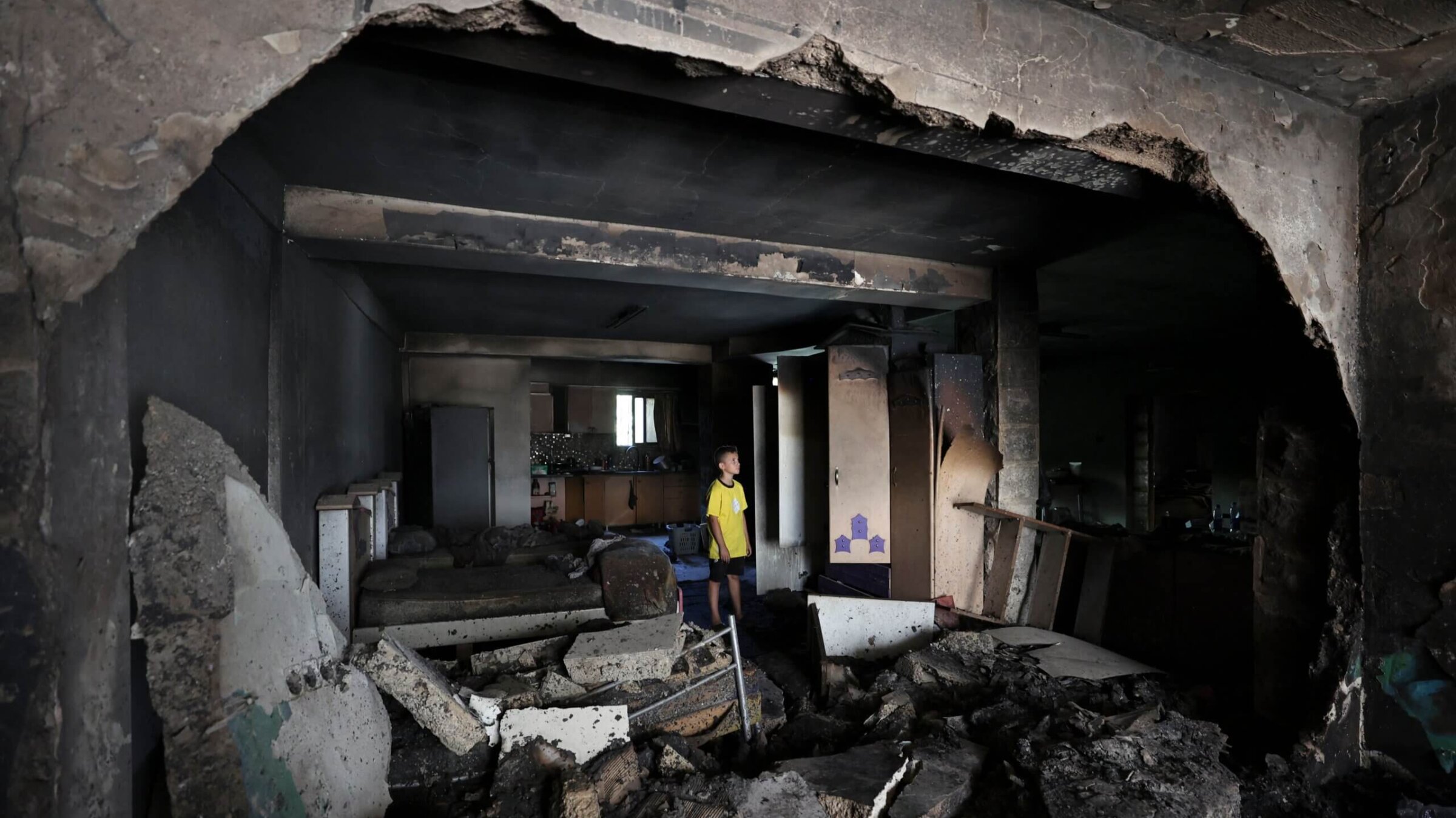 A boy checks the damage inside a house in the occupied West Bank Jenin refugee camp on July 6, 2023, following a large-scale Israeli military operation that lasted for two days. 