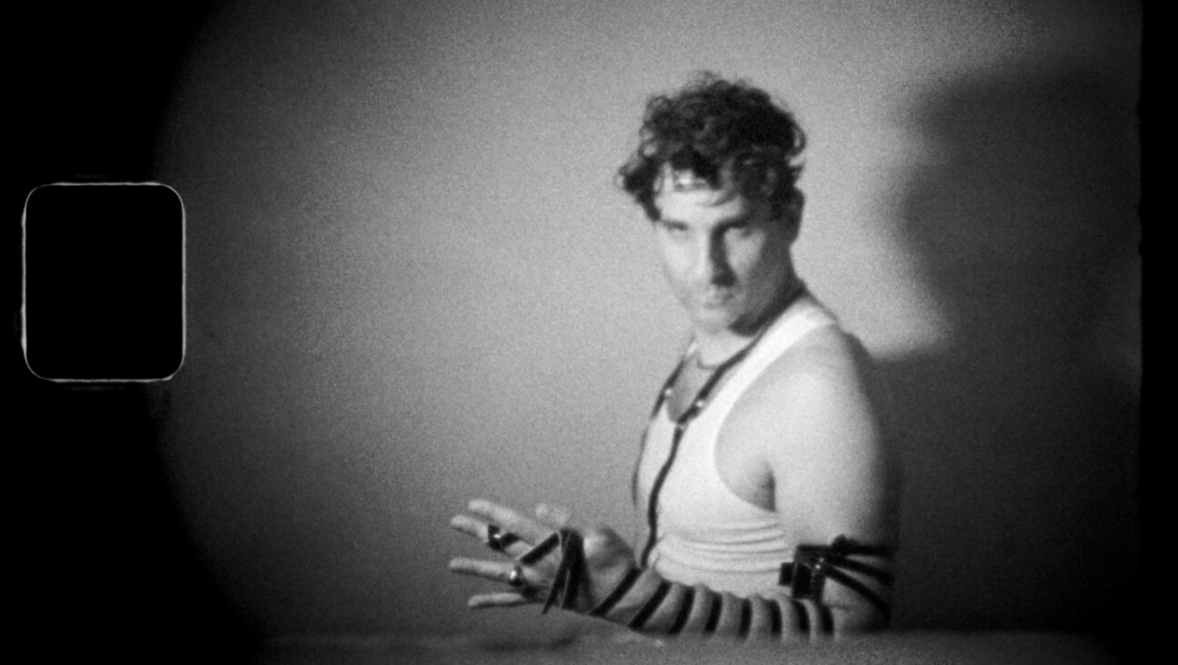 Adam Weiner wraps tefillin in his music video for the Low Cut Connie song “King of the Jews.” (Bob Sweeney)