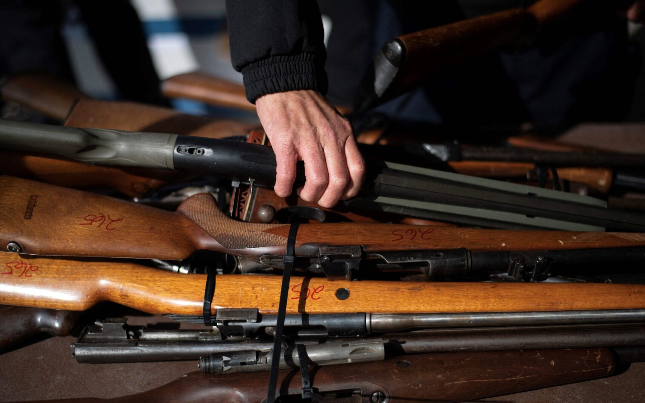 A police officer moves a rifle during a gun buyback program in Houston, Texas, Feb. 18, 2023. (Mark Felix/AFP via Getty Images)