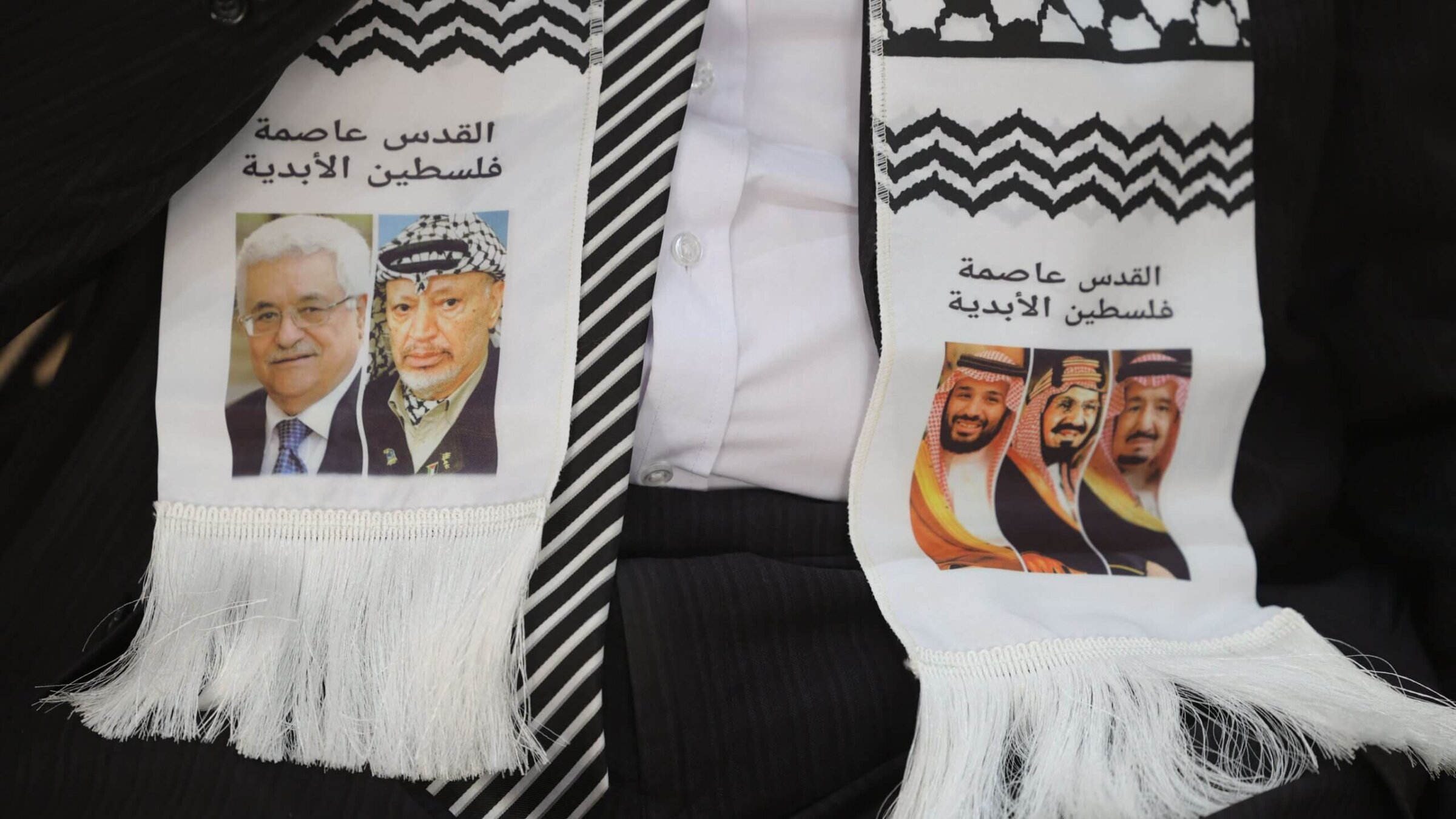 Palestinian ambassador to Saudi Arabia Bassem al-Agha wears a scarf depicting Palestinian and Saudi leaders, during a condolences reception for slain Al-Jazeera reporter Shireen Abu Akleh at the Palestinian embassy in the Saudi capital Riyadh on May 17, 2022. The scarf reads in Arabic "Jerusalem is the capital of Palestine" and depicts (L to R) Palestinian president Mahmud Abbas and his predecessor Yasser Arafat, Saudi Arabia's Crown Prince Mohamed bin Salman bin Abdulaziz al-Saud, the kingdom's founding King Abdulaziz ibn Saud, and current leader, King Salman bin Abdulaziz. 