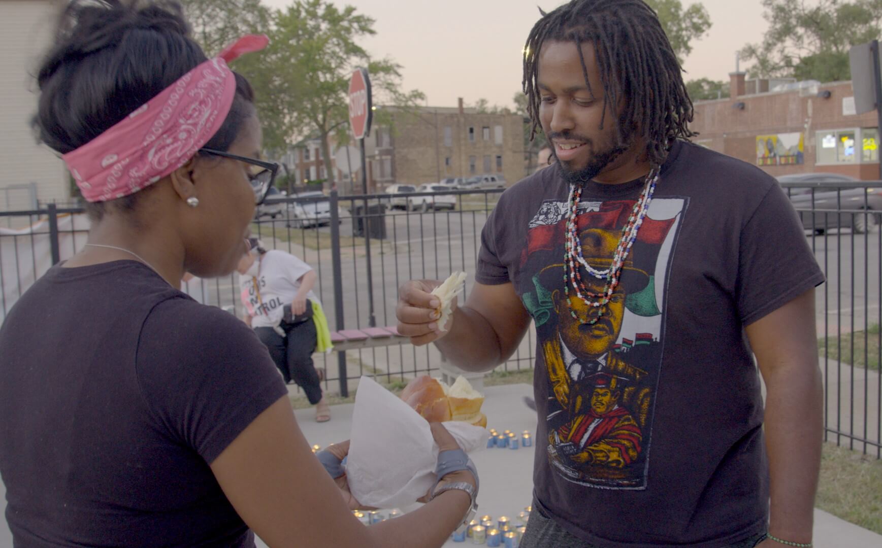 Rabbi Tamar Manasseh shares challah with a participant at the break-the-fast following a Yom Kippur service on a Chicago street corner in memory of victims of violent deaths during the previous year.