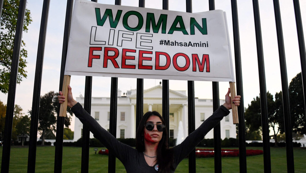 A woman holds a placard as protesters march in solidarity with protesters in Iran in front of the White House in Washington, DC, on October 22, 2022.