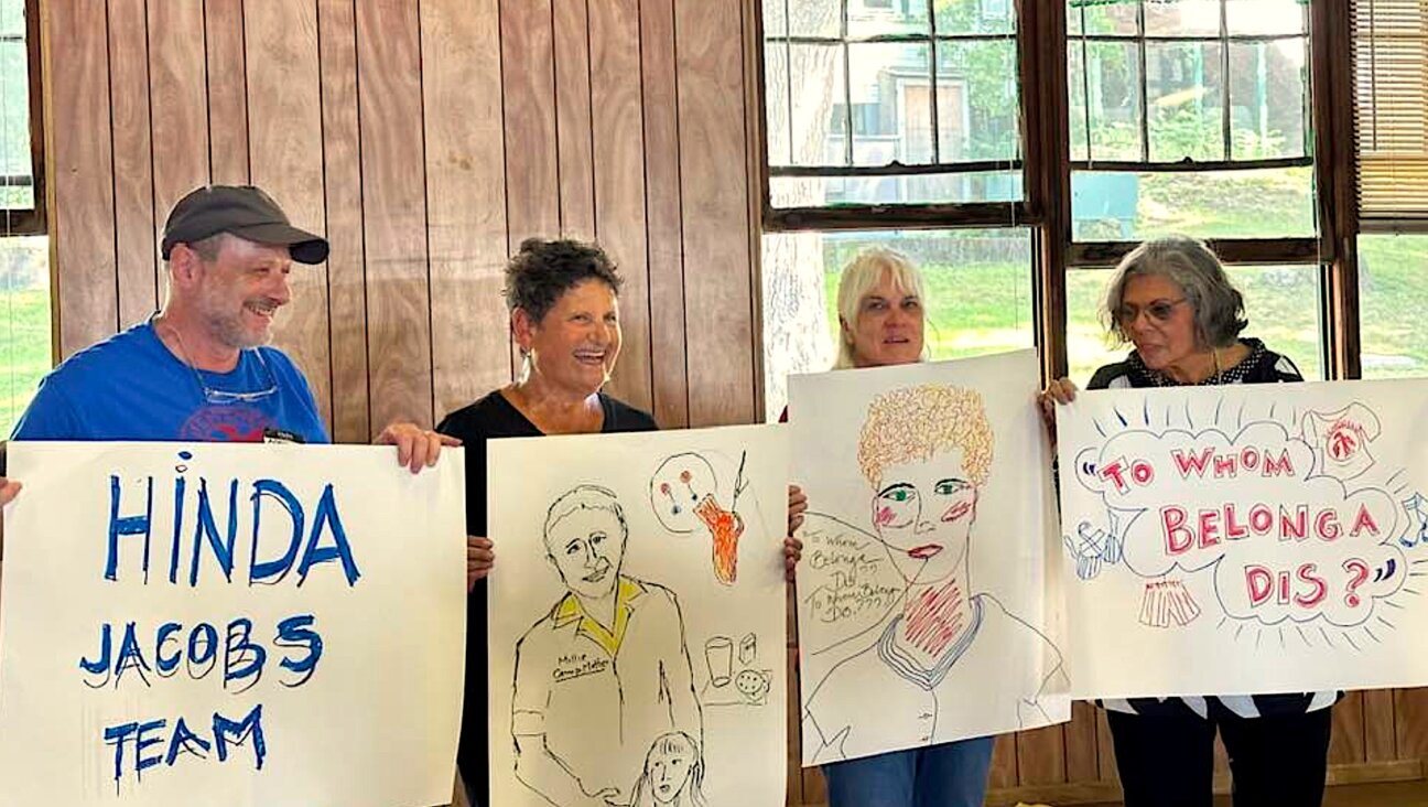 Members of the Hinda Jacobs team display the posters they had created, during the Camp Hemshekh reunion